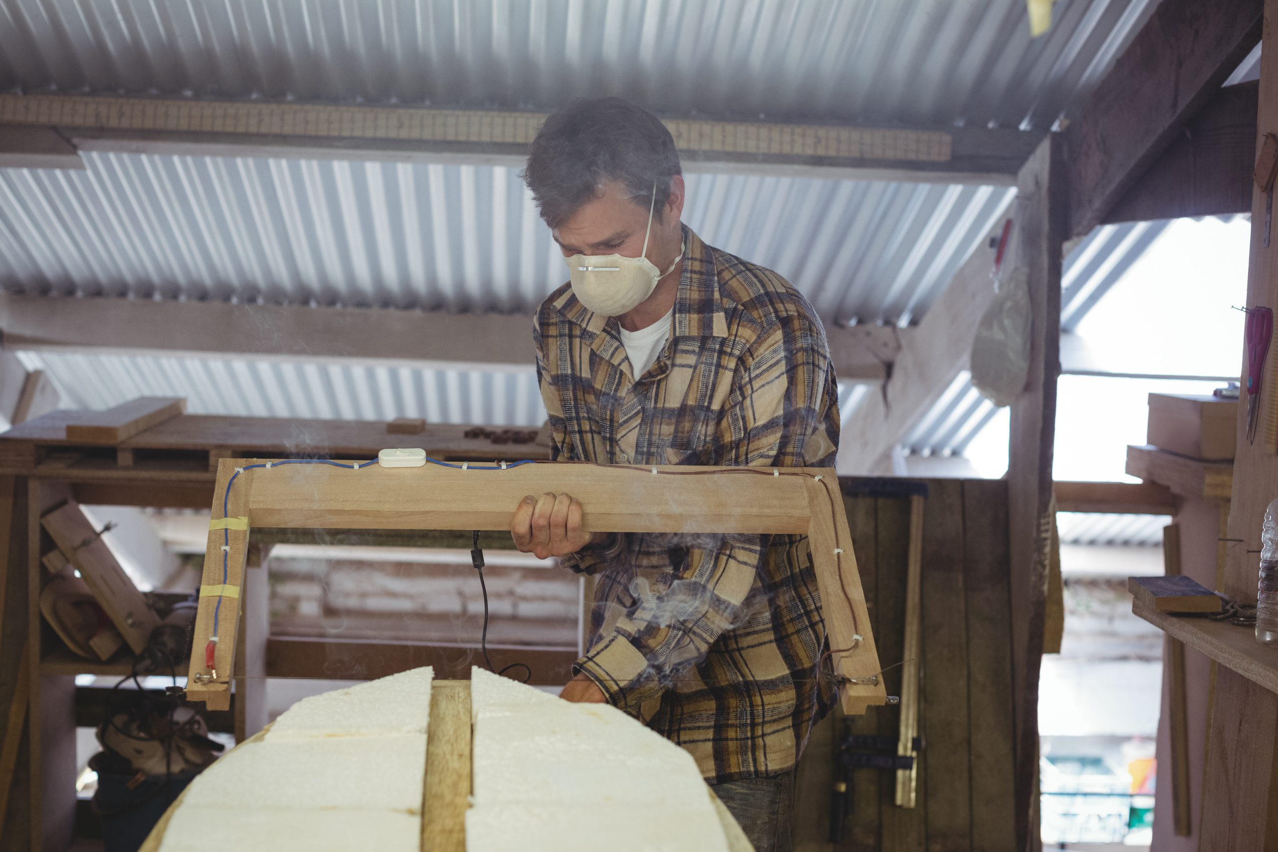 Man making surfboard in workshop